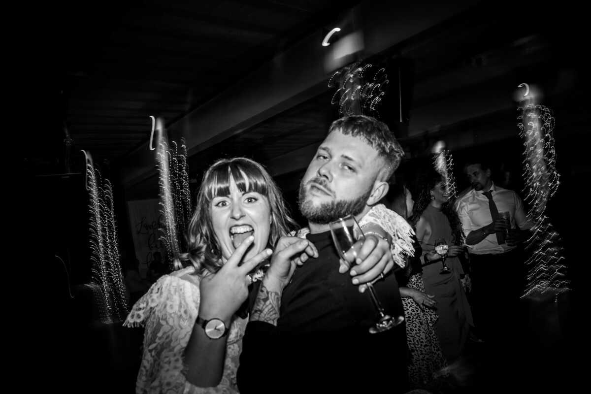 Smiling couple celebrating with drinks at a party.