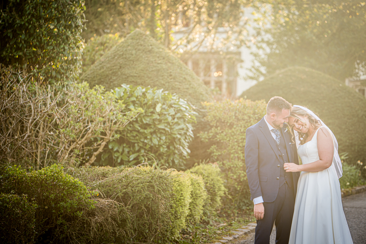 Smiling wedding couple in sunny garden setting