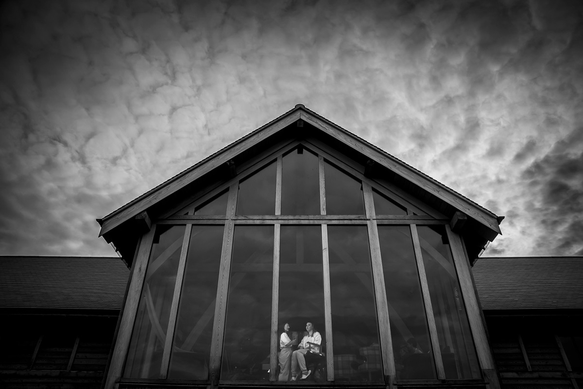 Black and white house with large front windows.