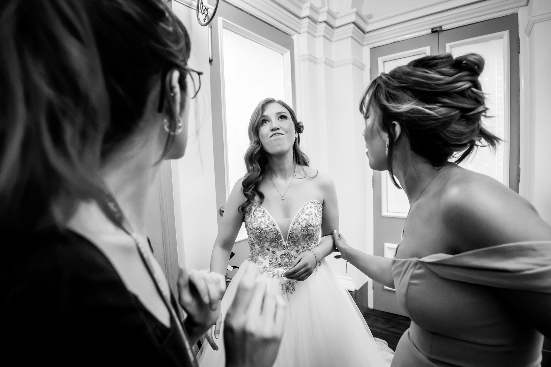 Bride getting ready with her bridesmaids, smiling.