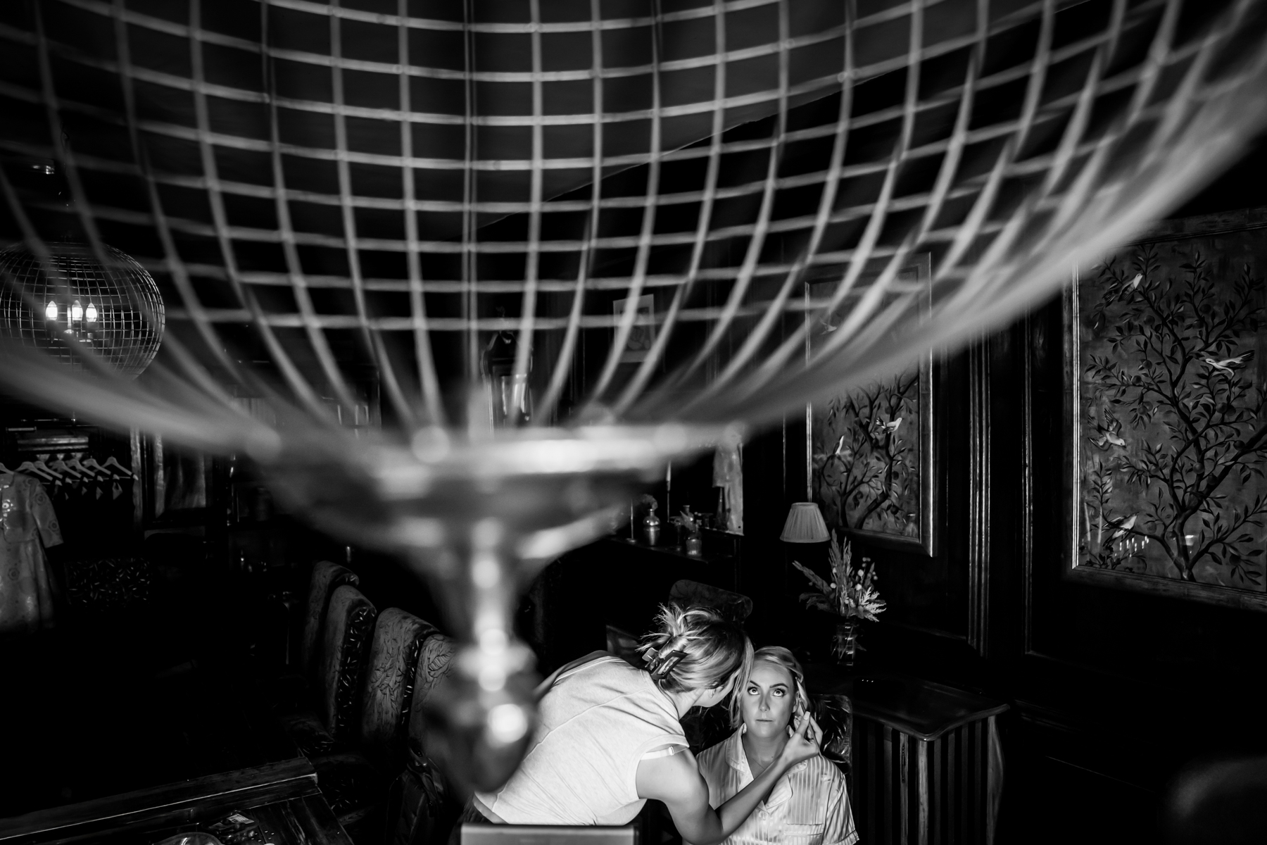 Bridal makeup preparation in elegant, ornate room.