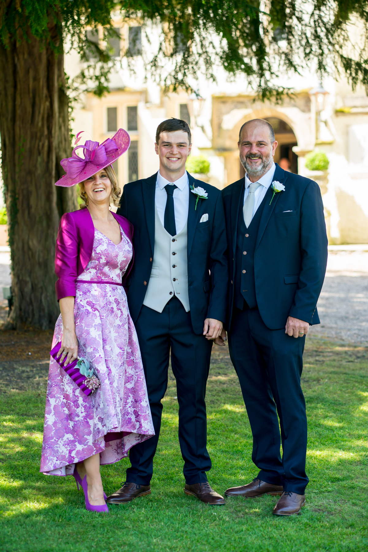 Three people in formal attire at outdoor event.
