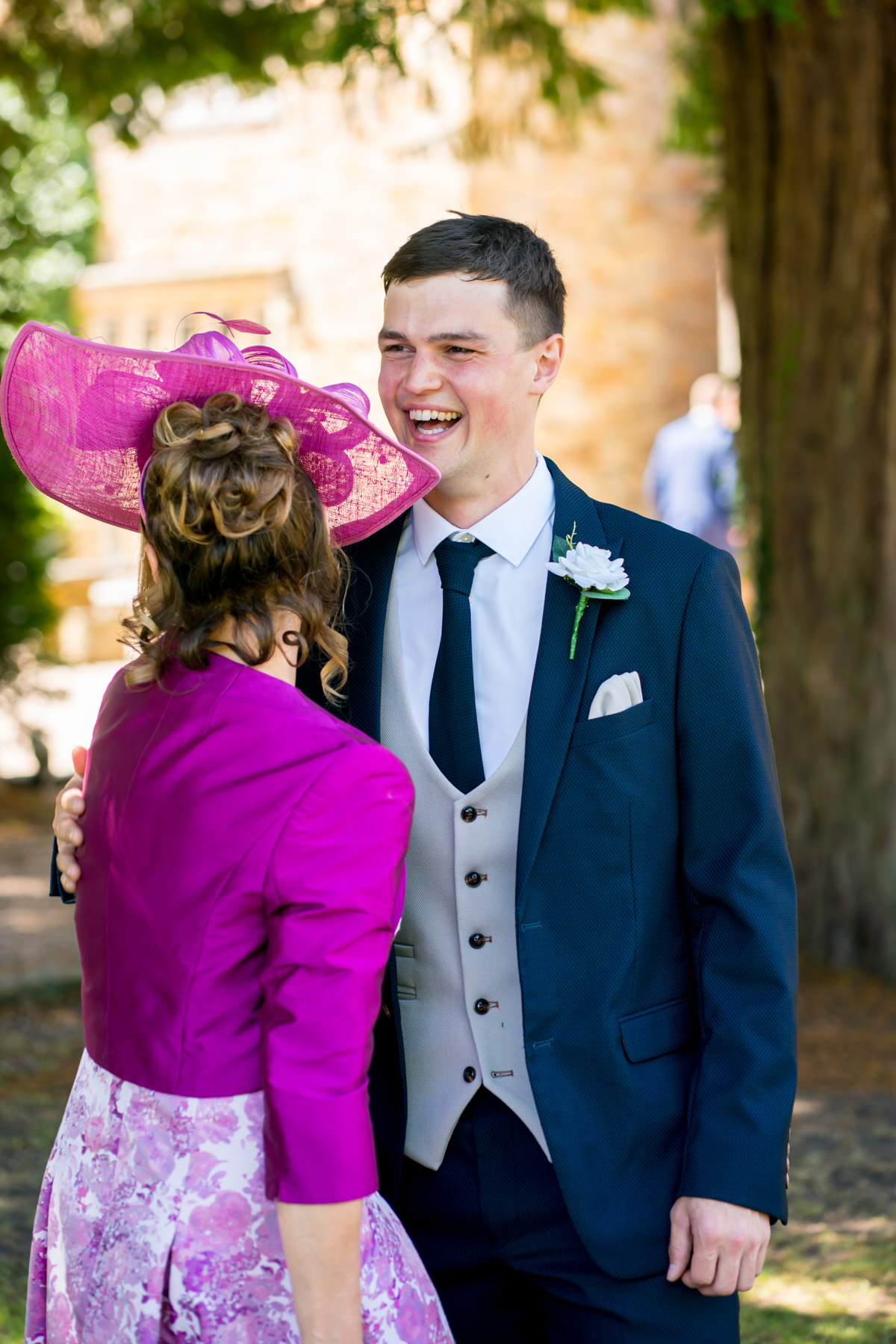 Guests smiling at outdoor wedding celebration.