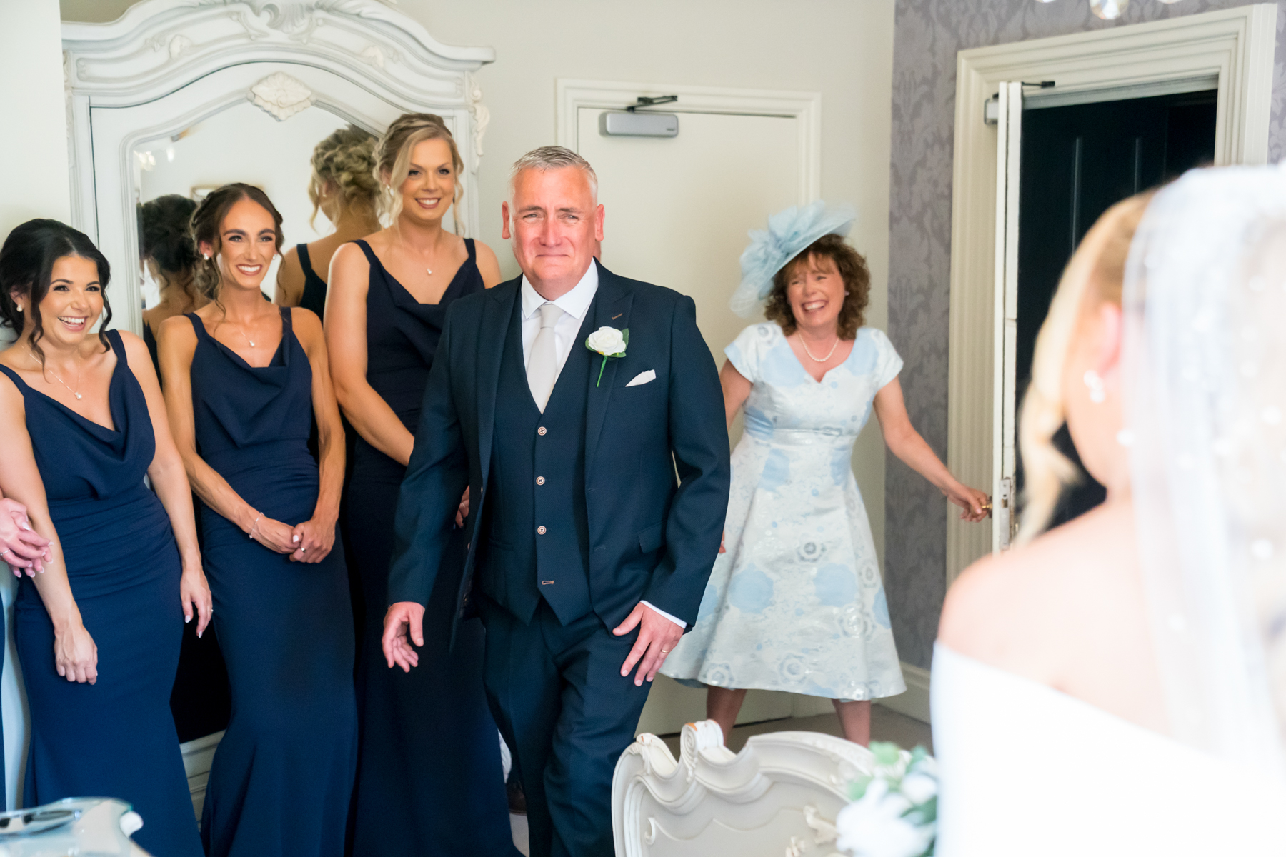 Bridal party smiling in elegant dresses and suits.