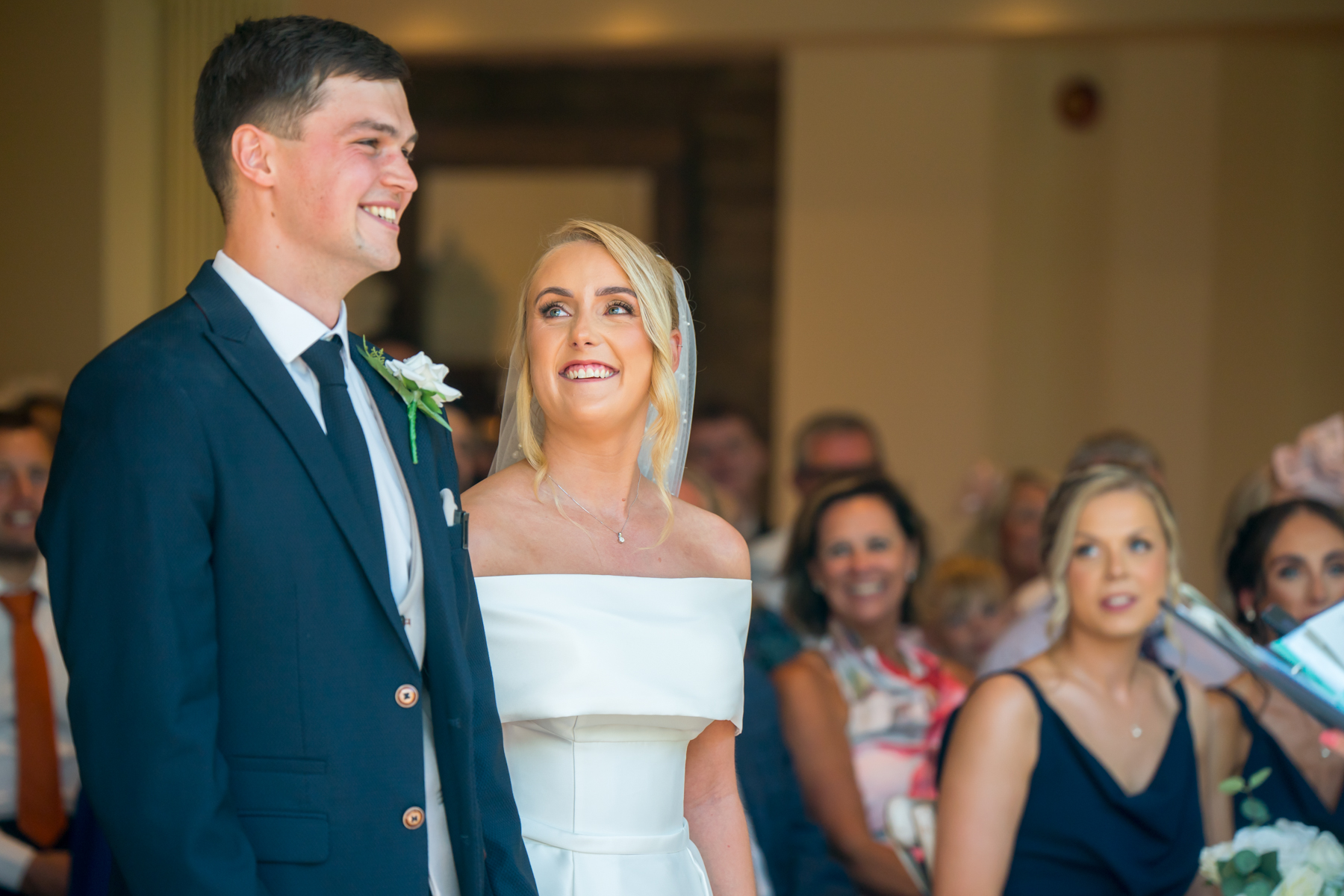 Bride and groom smiling at wedding ceremony.