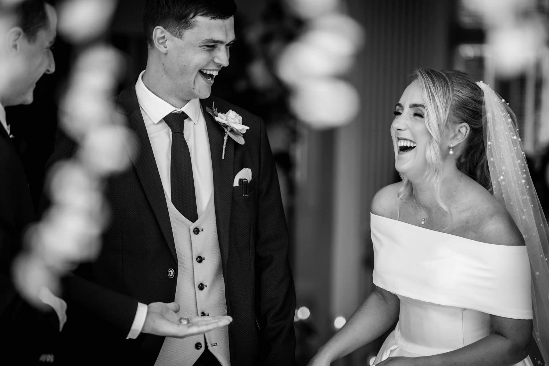 Bride and groom laughing joyfully at wedding ceremony.