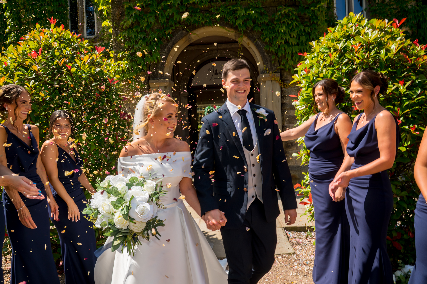Bride and groom exiting church under confetti shower.
