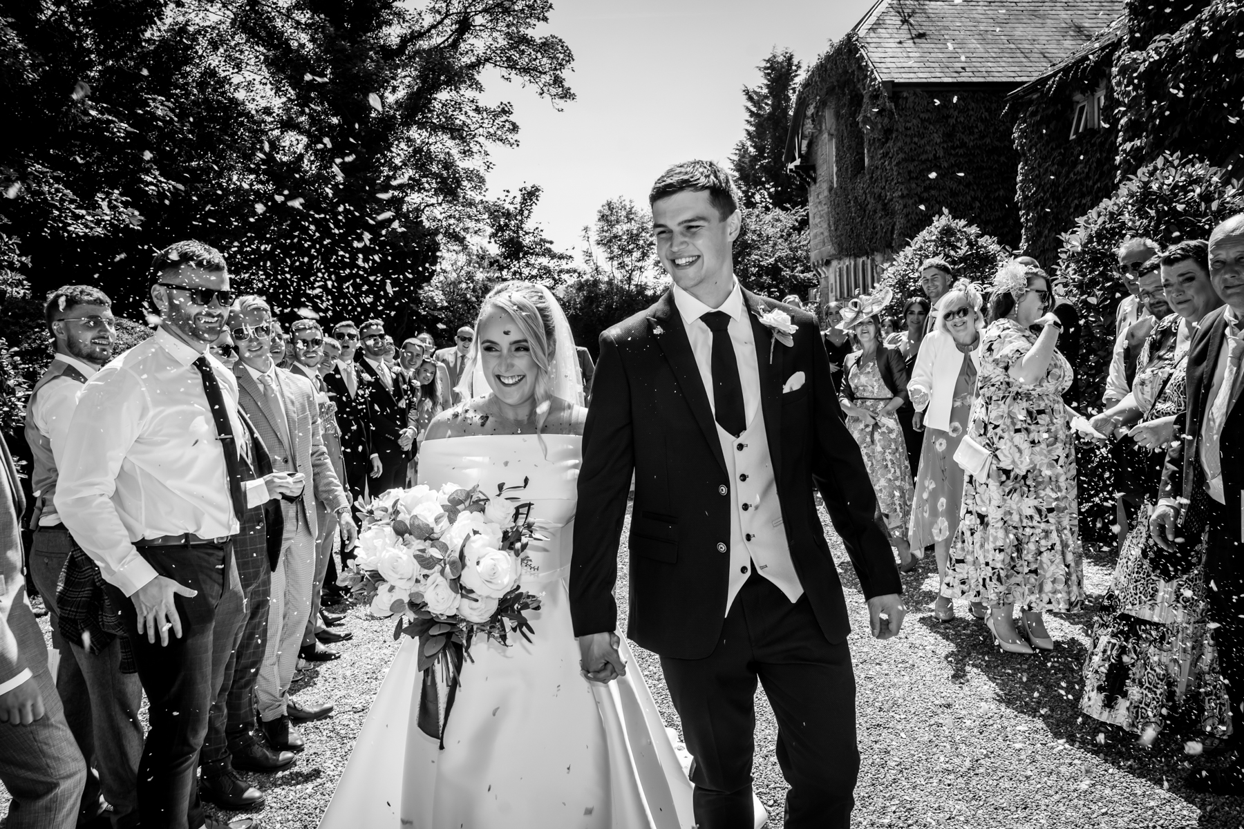 Bride and groom walking through confetti.
