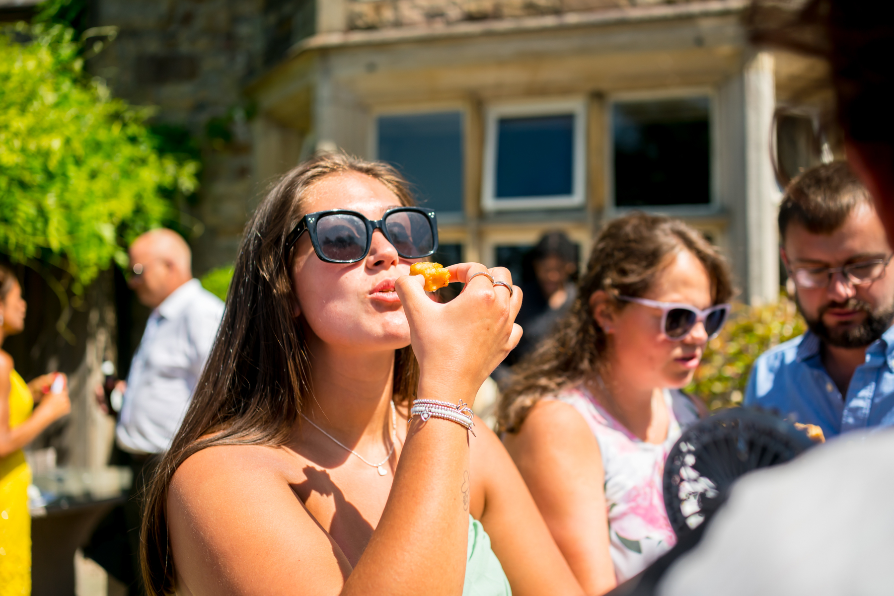People enjoying food outdoors in sunny weather.