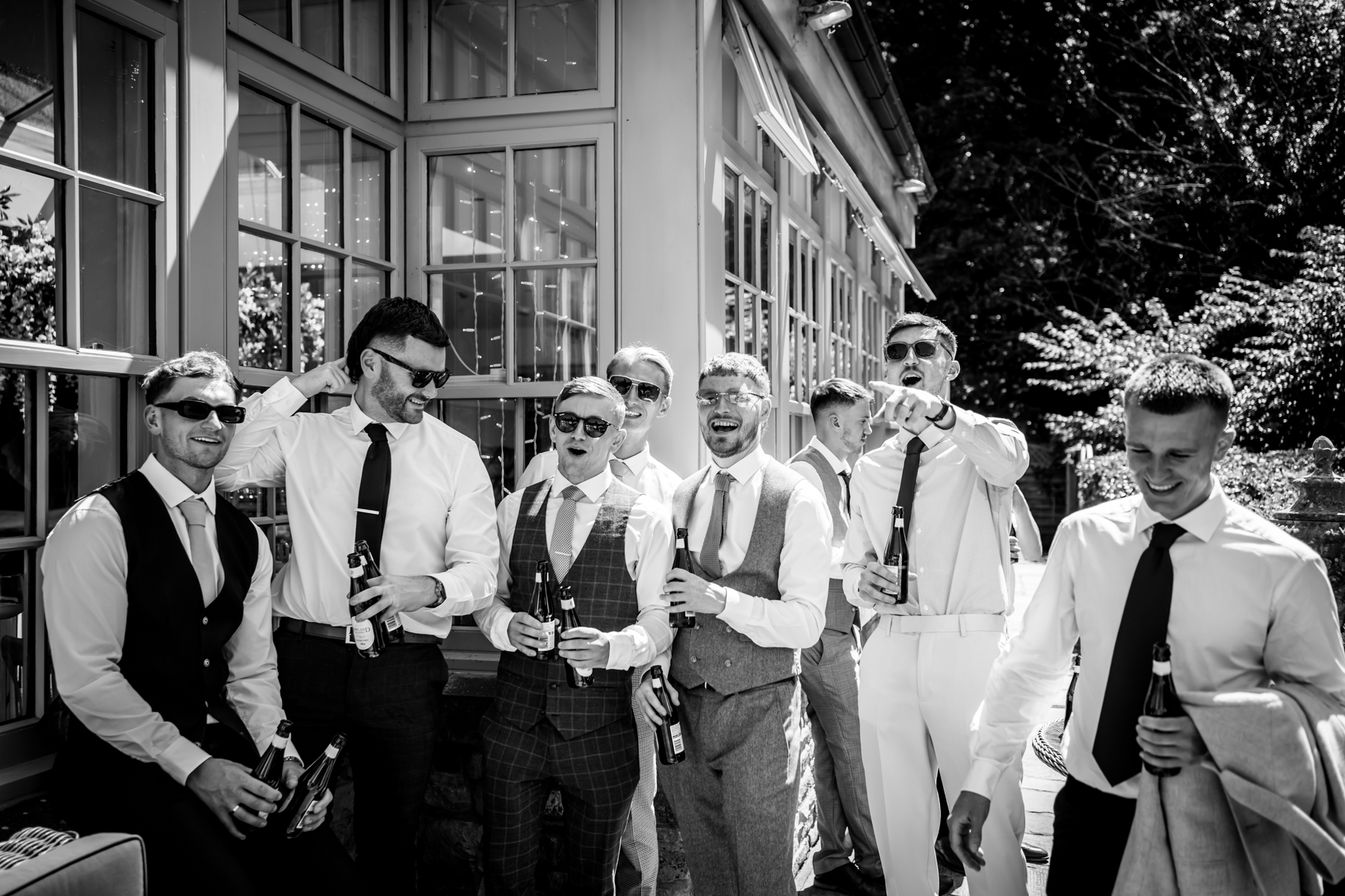 Group of men celebrating with drinks outside.