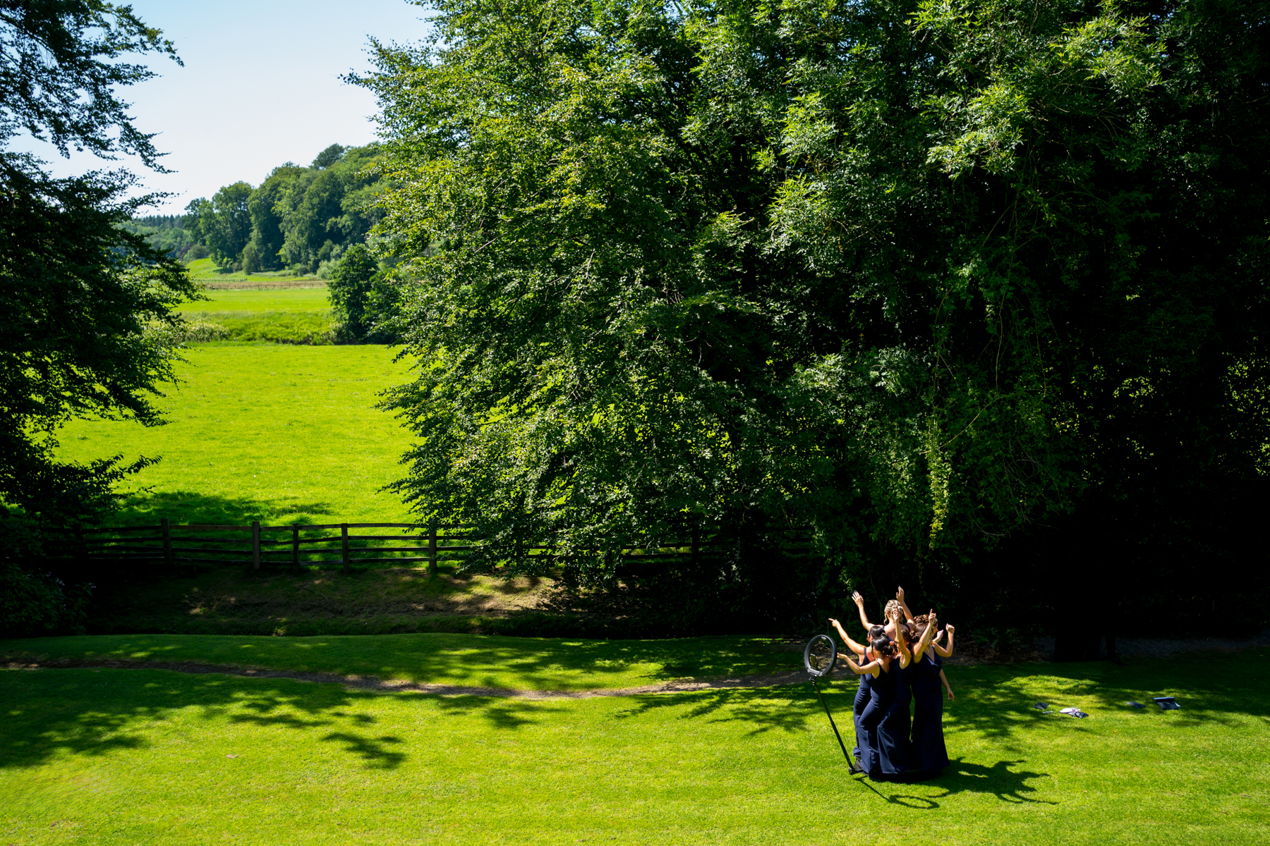 Women celebrating in sunny park.