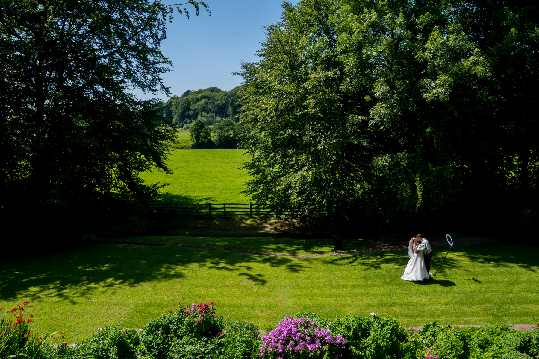 Bride and groom kissing in sunny garden