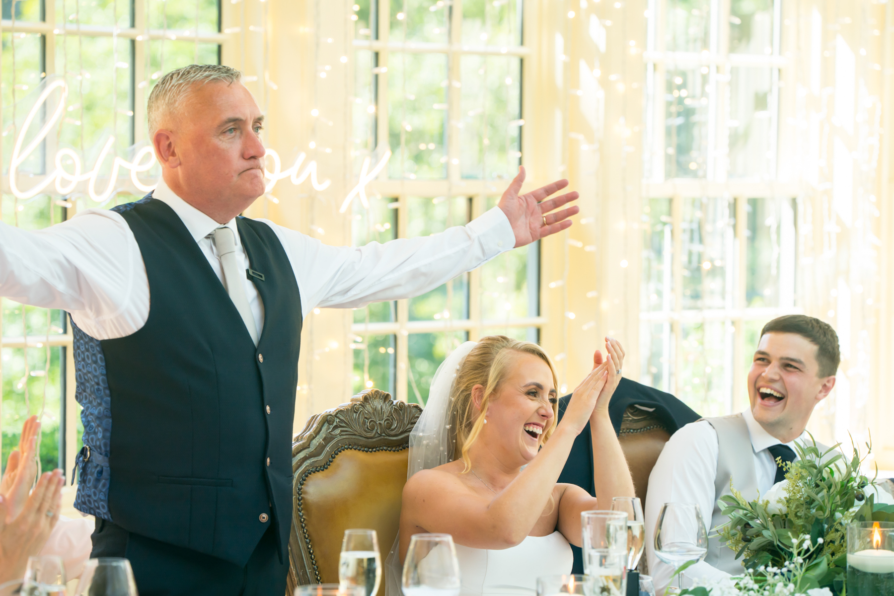 Wedding speech with bride and groom applauding joyfully.