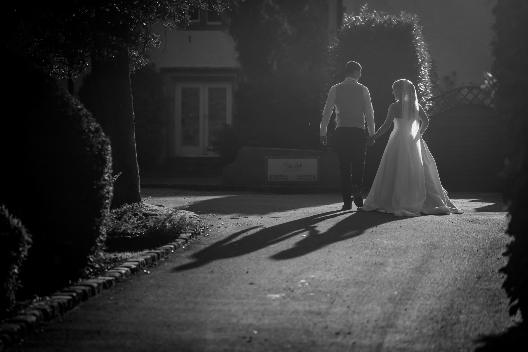 Bride and groom walking hand in hand.