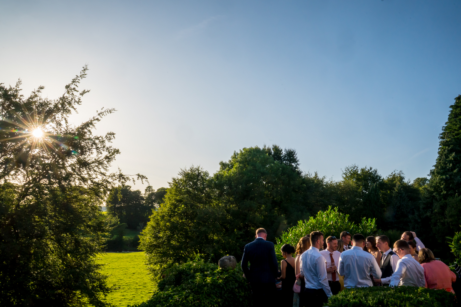 People conversing in sunny, green countryside