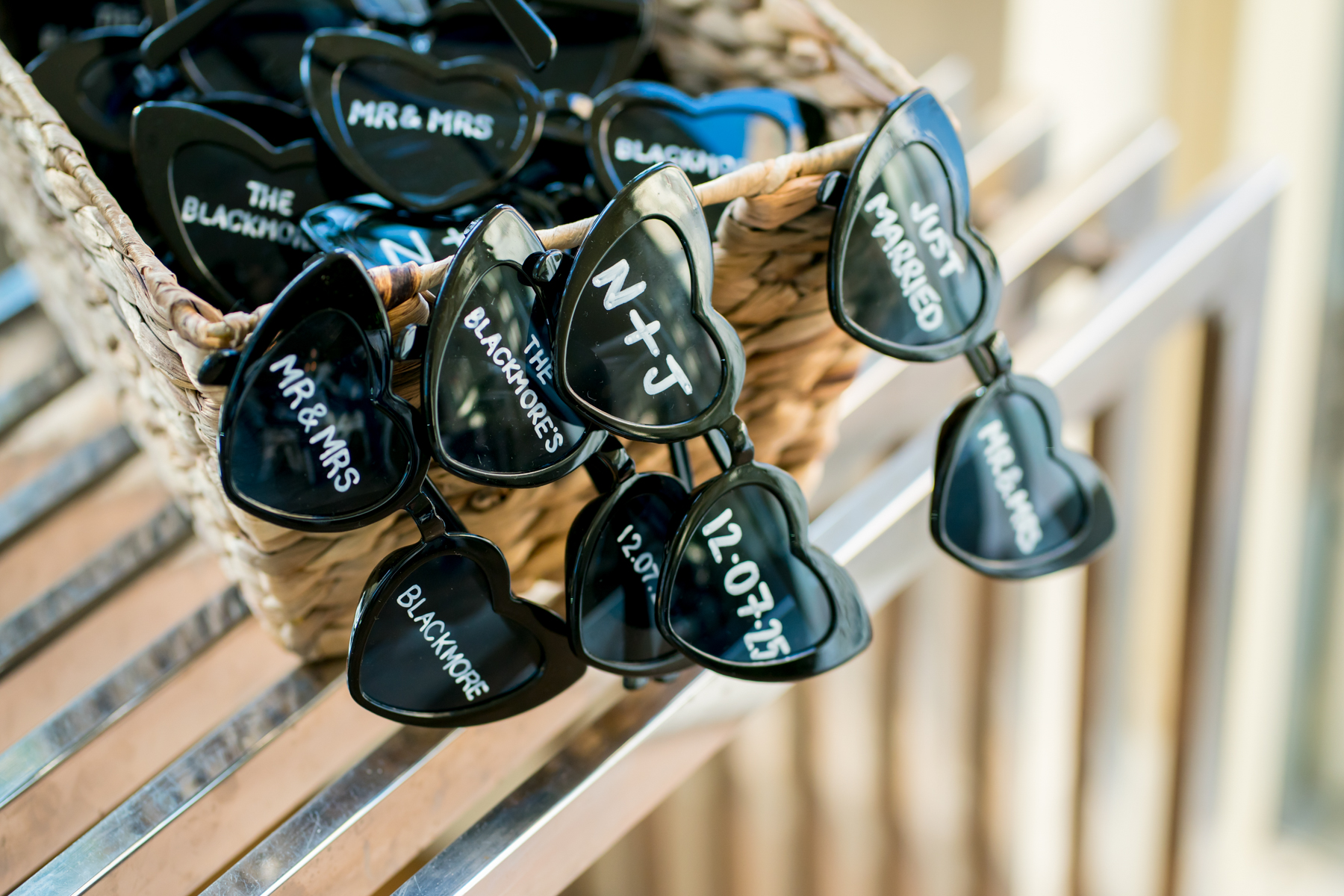 Wedding-themed heart sunglasses in a wicker basket.