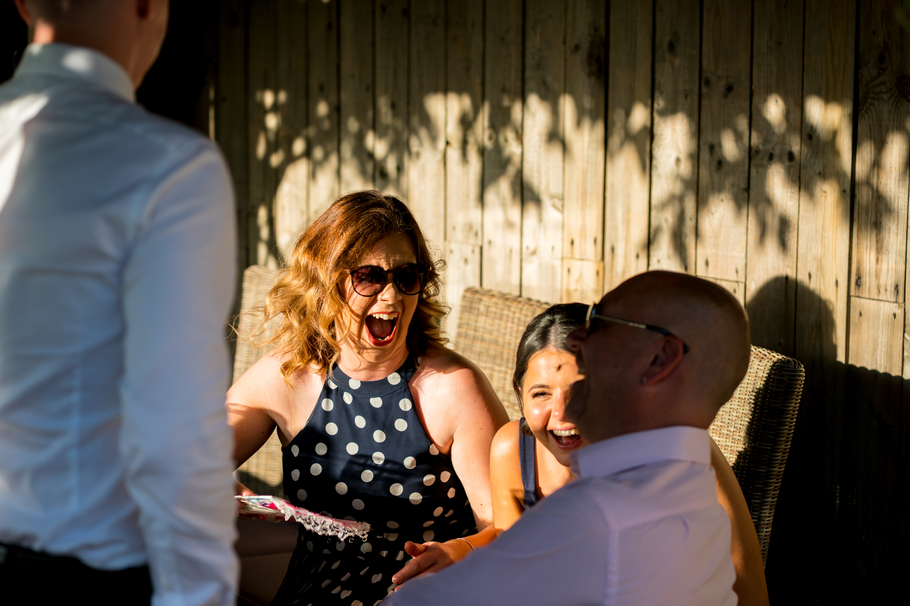 Group laughing together outdoors, enjoying sunlight.