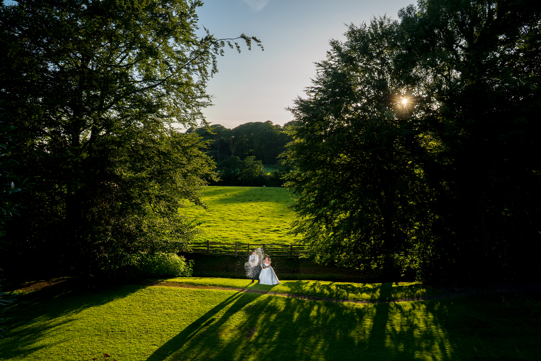 Bride and groom walking in sunlit garden