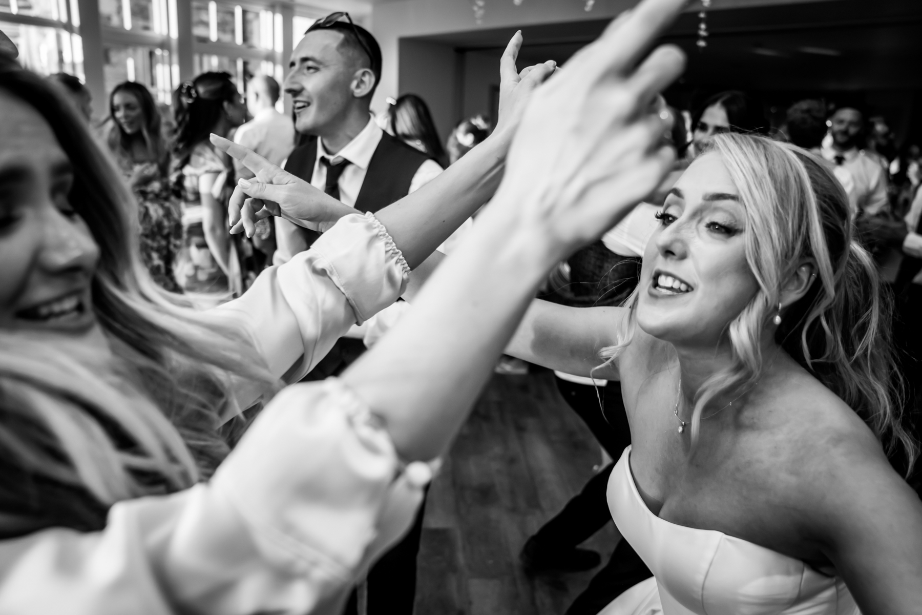 Guests joyfully dancing at a wedding reception.