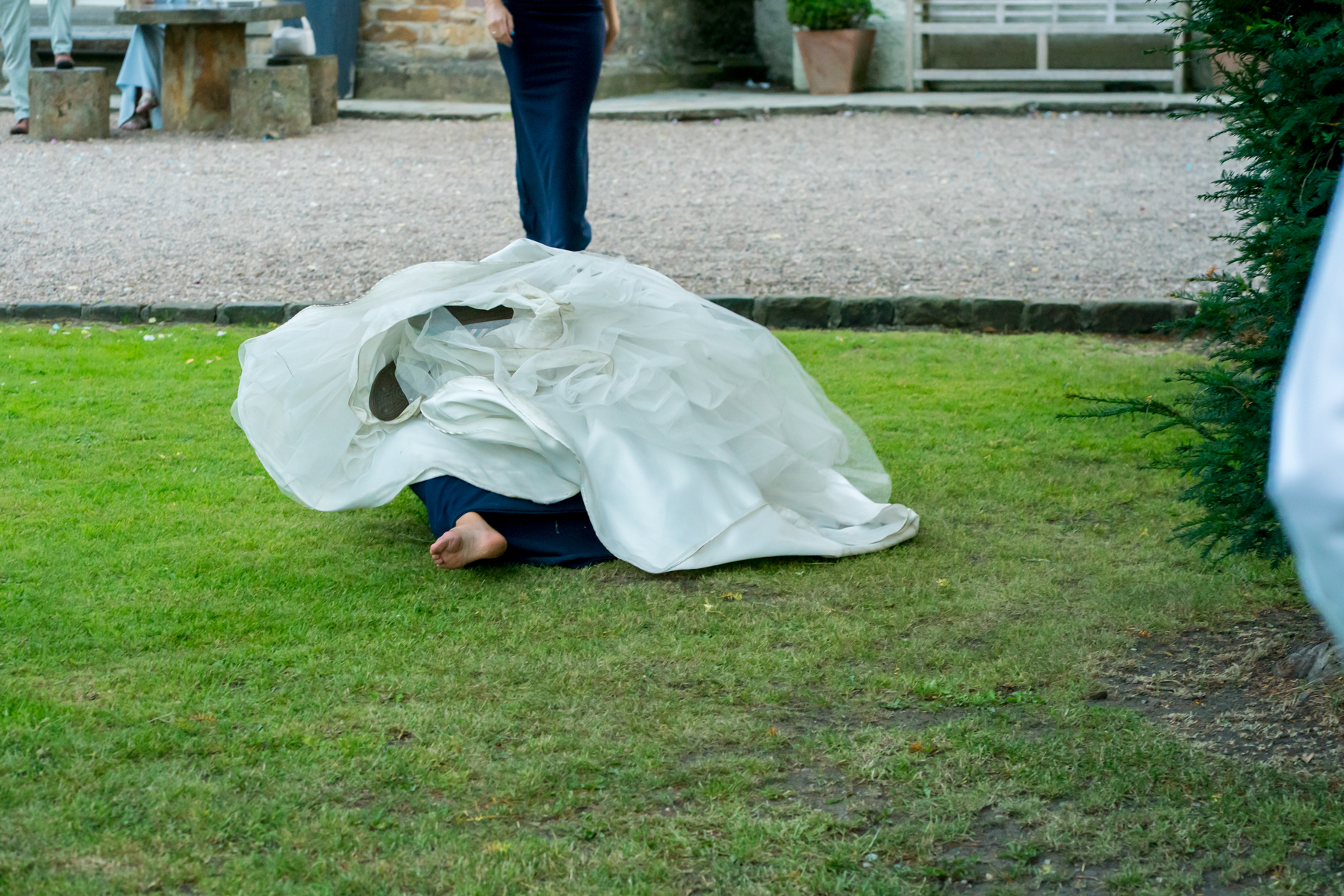 Person falling in wedding dress on grass.