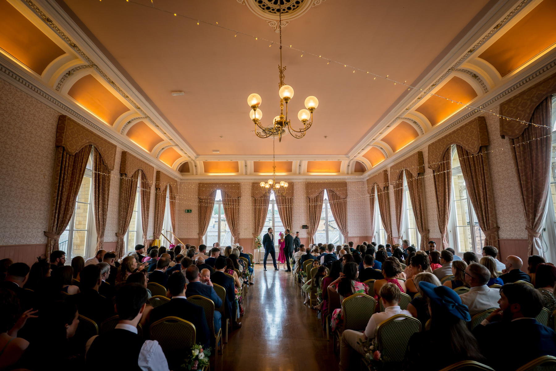 Elegant indoor wedding ceremony with seated guests.