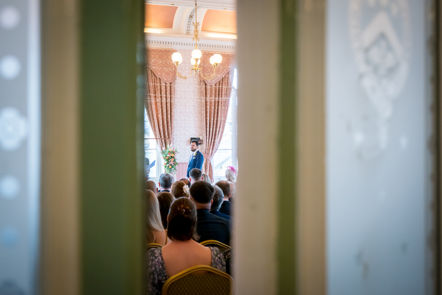 Wedding ceremony viewed through a doorway