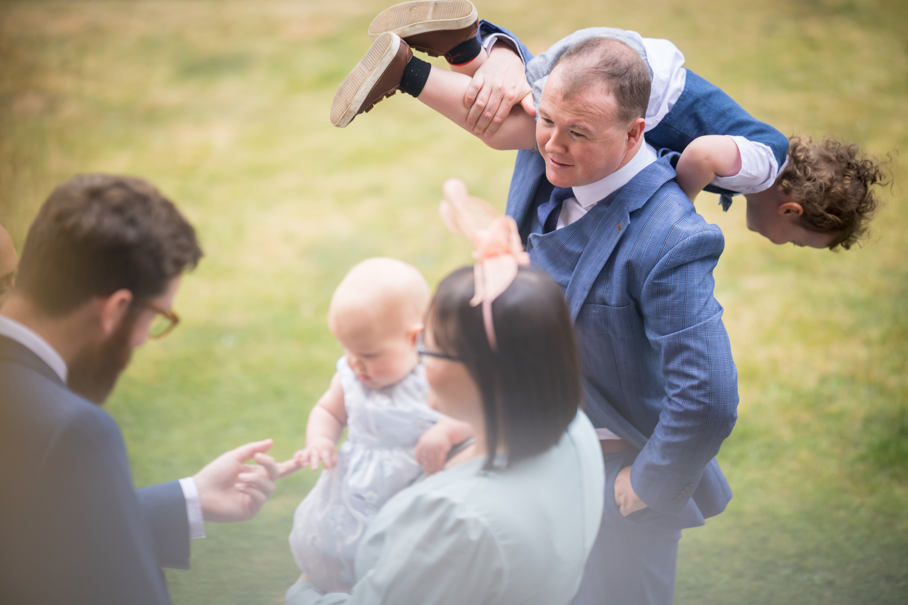 Family gathering outdoors, child on shoulder