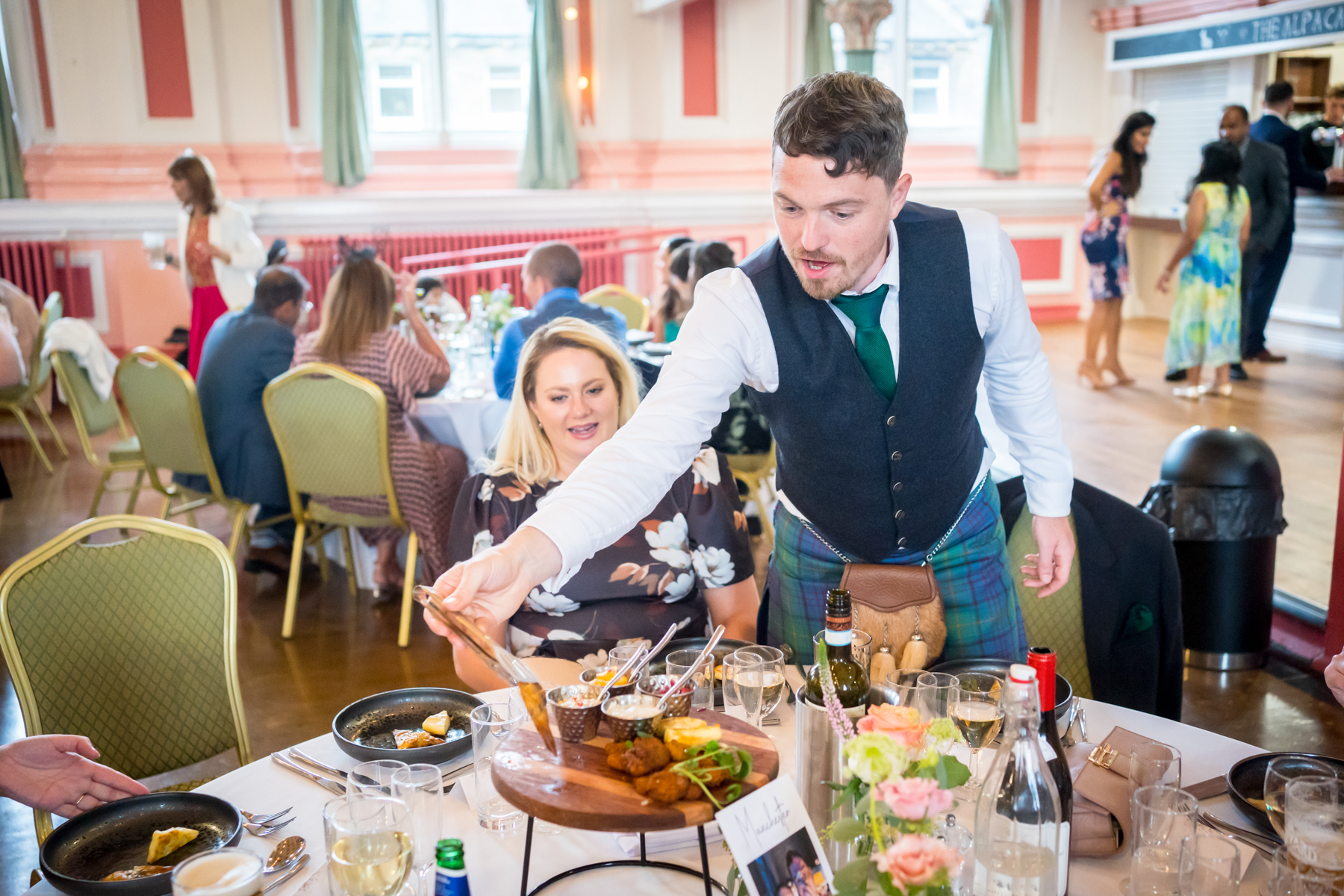 Man serving food at a formal dining event.