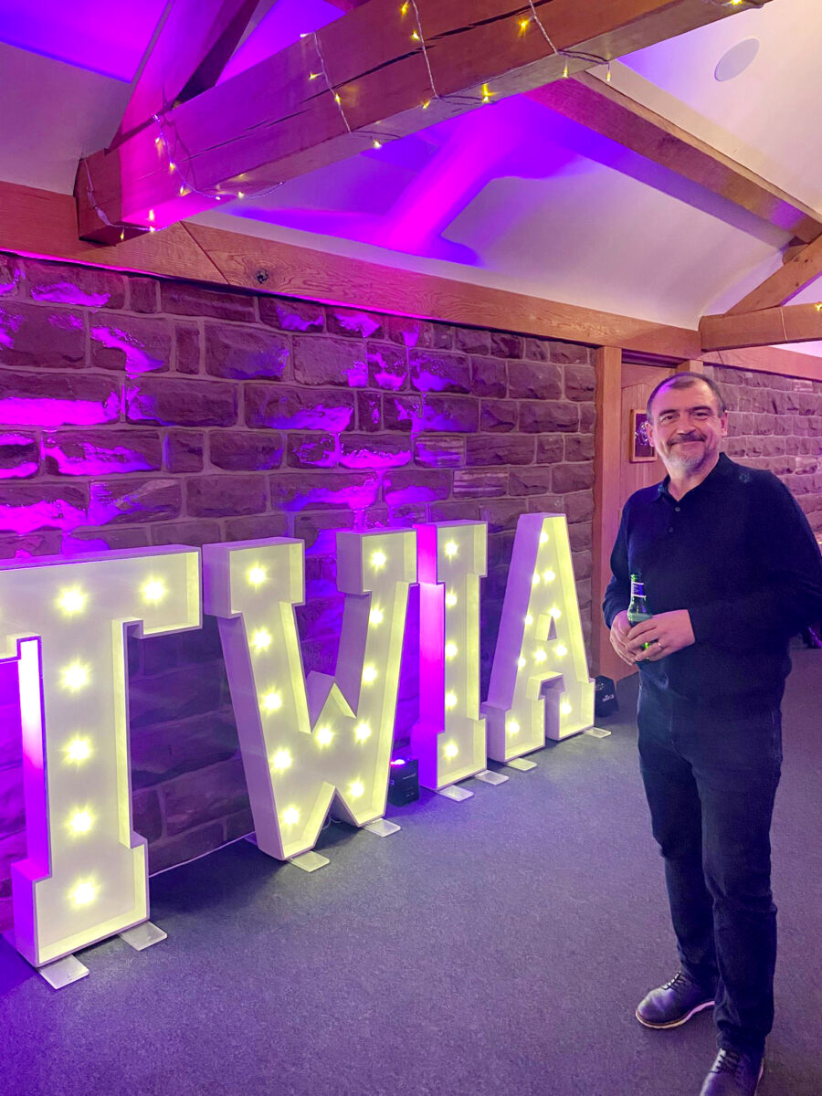 Man at TWIA event with illuminated letters.