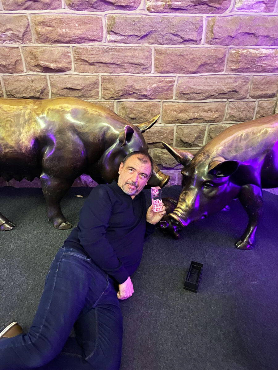 Man posing with bronze bull sculptures indoors