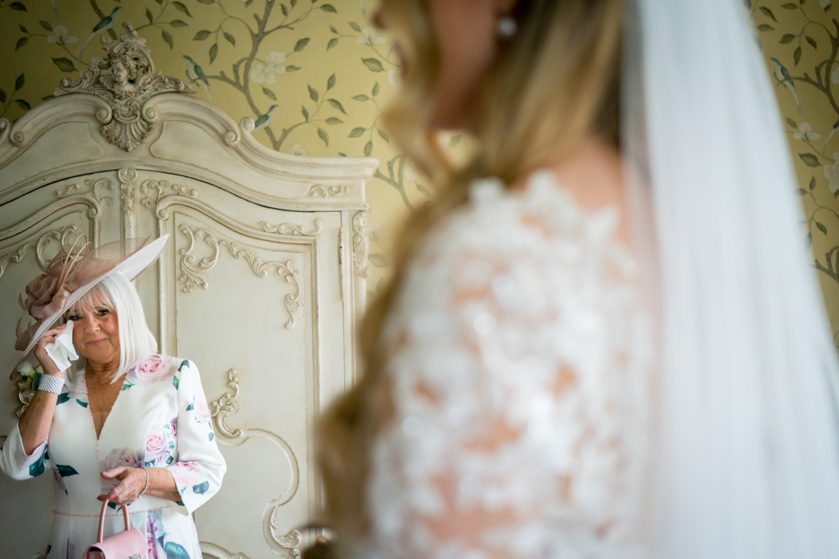 Emotional woman in floral dress at wedding.