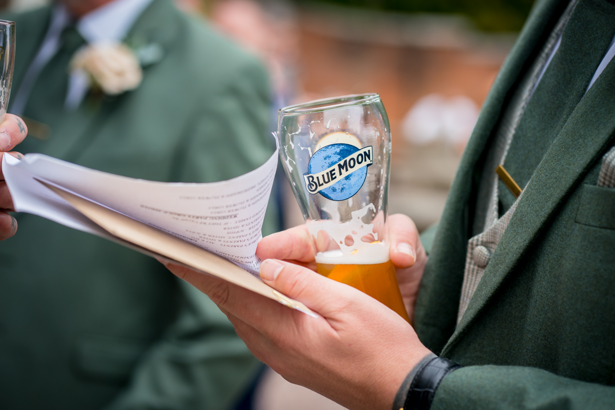 Person holding Blue Moon beer and papers.