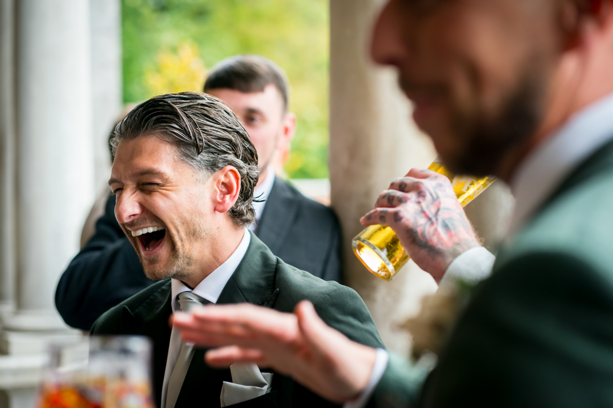 Man laughing at party, holding drink