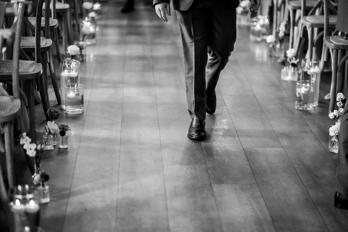 Man walking down decorated wedding aisle