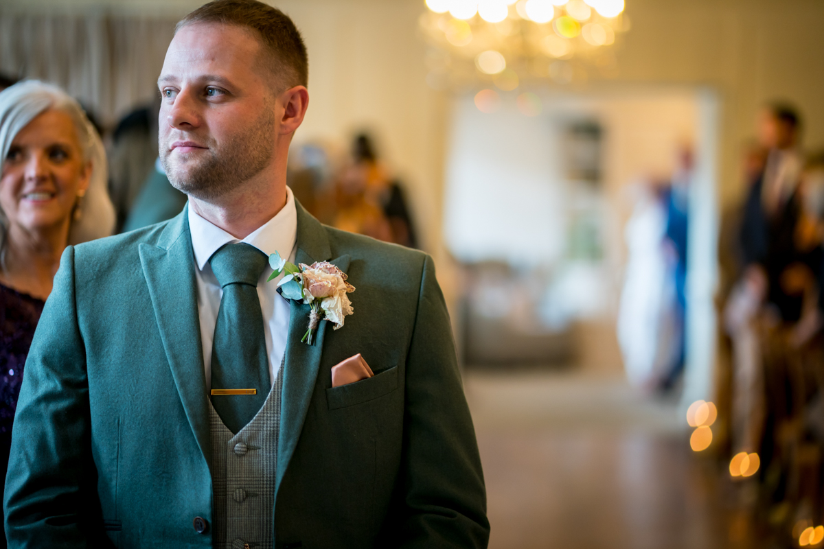Man in green suit at wedding ceremony