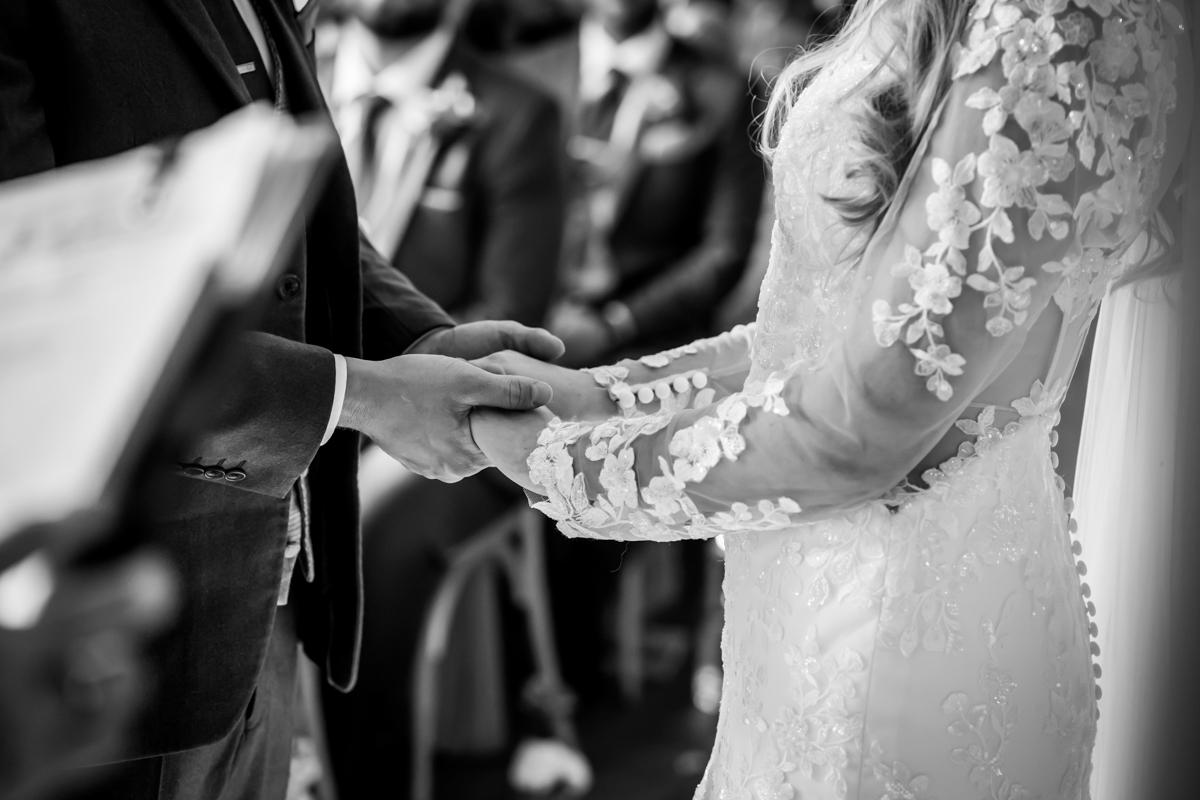 Bride and groom holding hands during wedding ceremony.