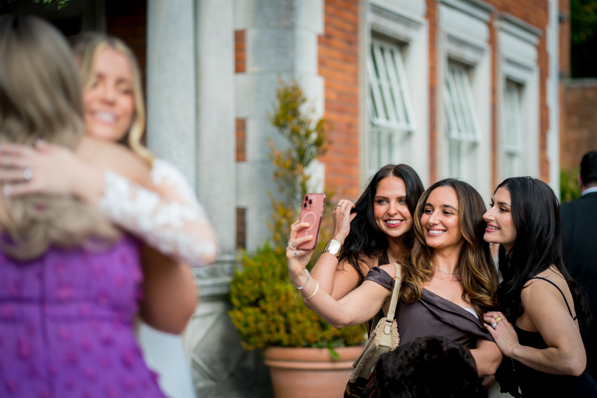 Three women taking a selfie at outdoor event.