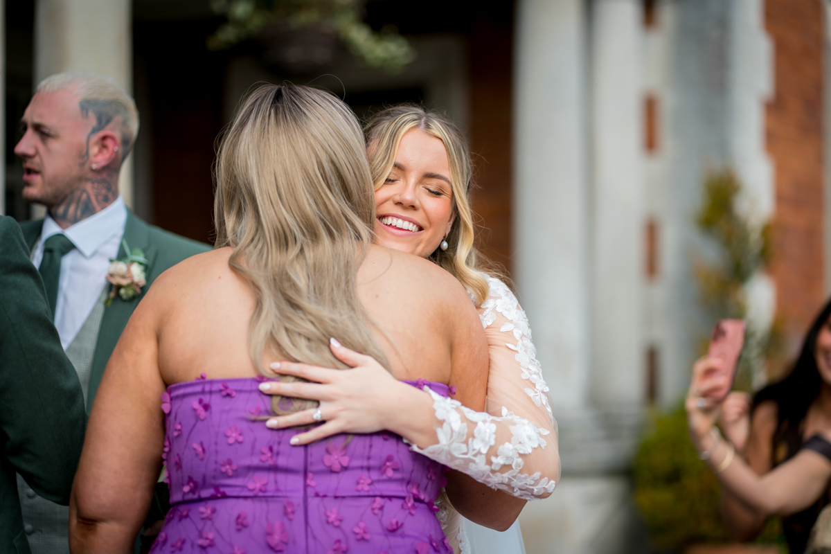 Bride hugging guest at wedding celebration