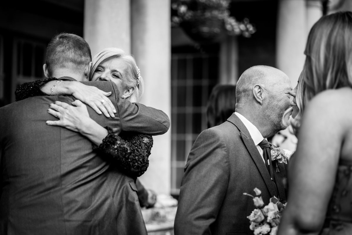 Black and white wedding guests embracing and kissing.