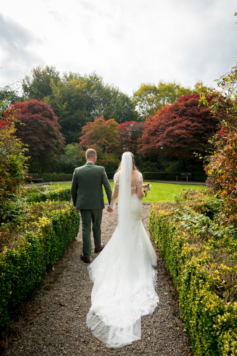 Bride and groom in picturesque autumn garden