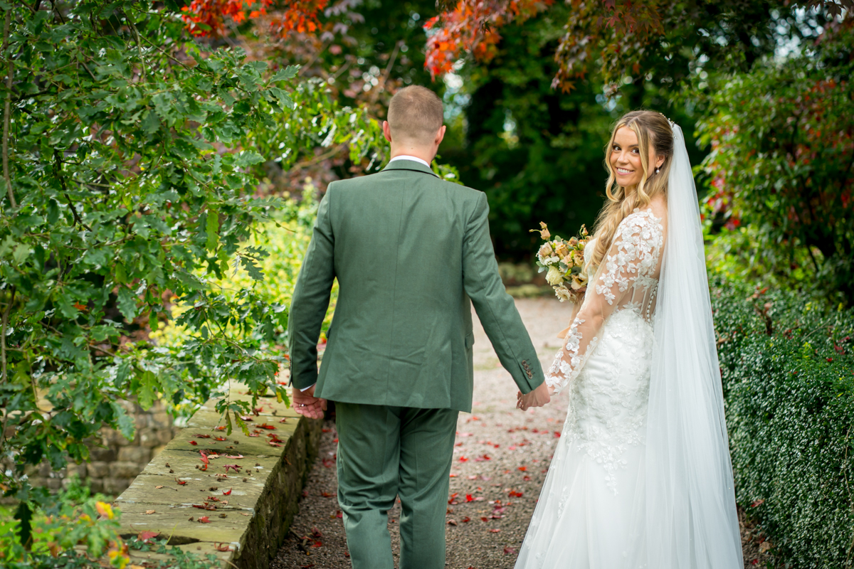 Bride and groom walking in garden path