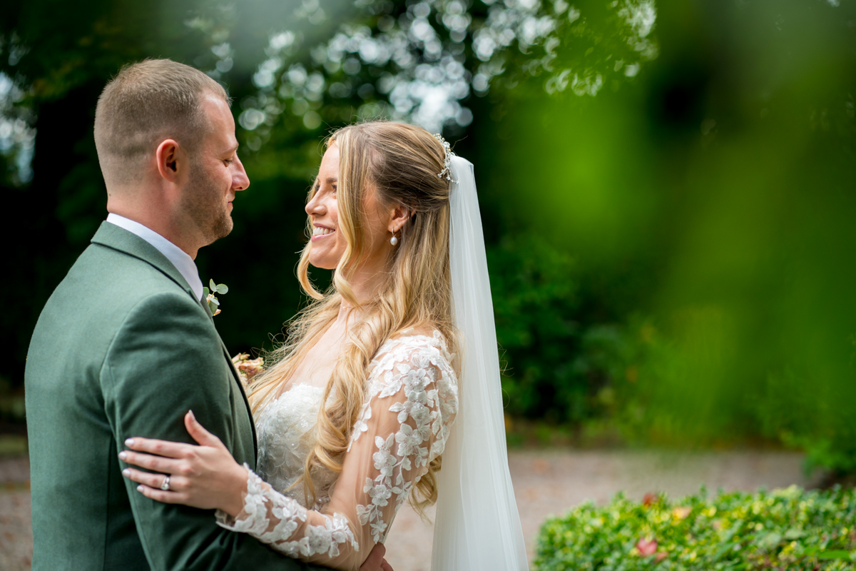 Bride and groom smiling in garden ceremony