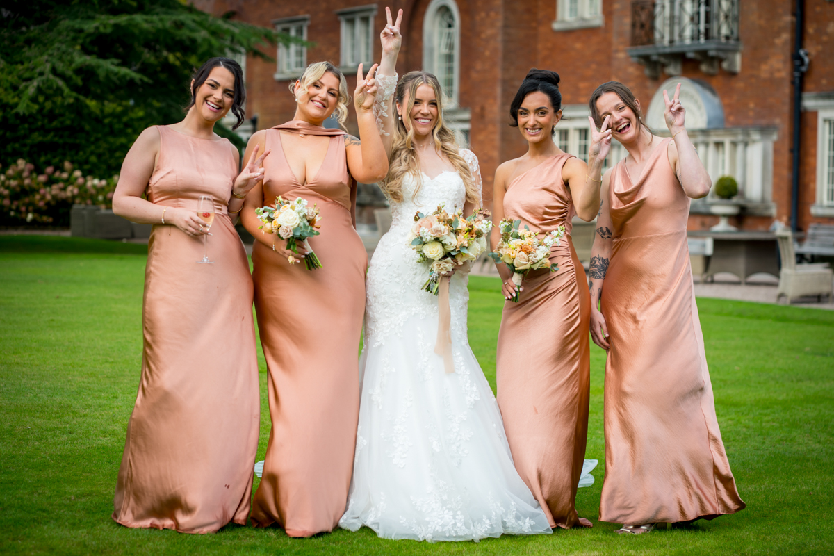 Bride and bridesmaids celebrating in garden setting.