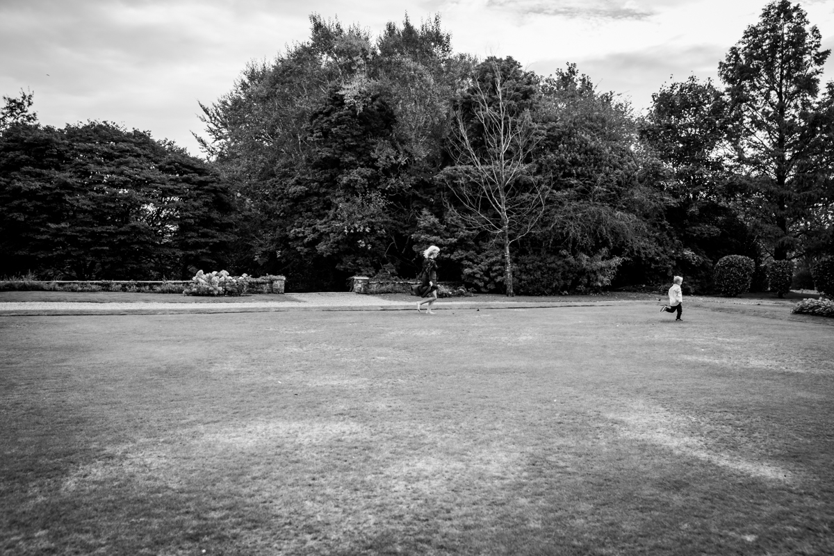 Children playing in grassy park with trees background
