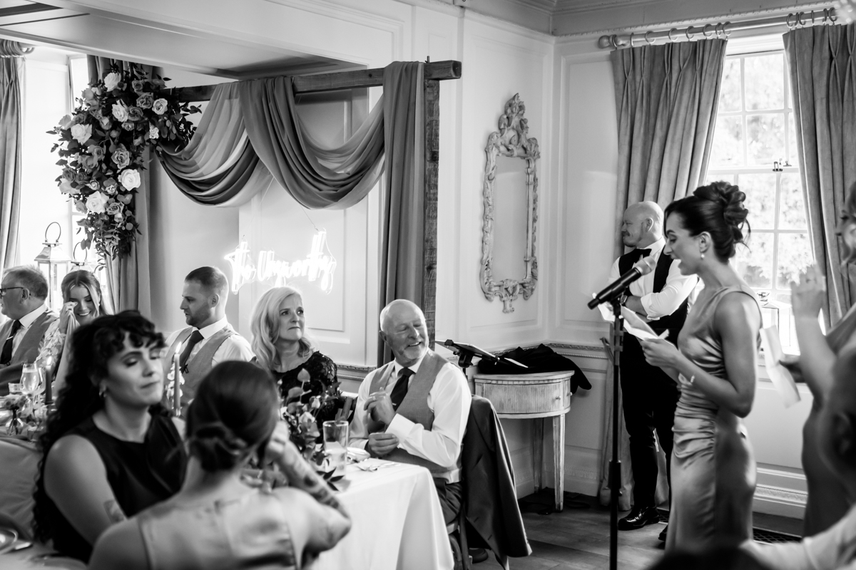 Wedding speech at reception with guests listening attentively.