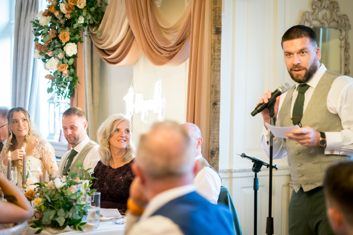 Best man giving speech at wedding reception.