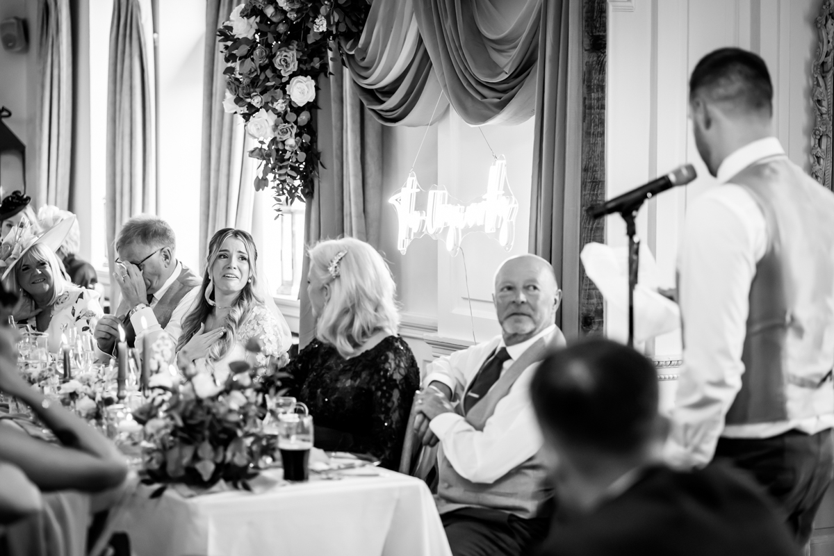 Wedding speech at reception with guests listening.