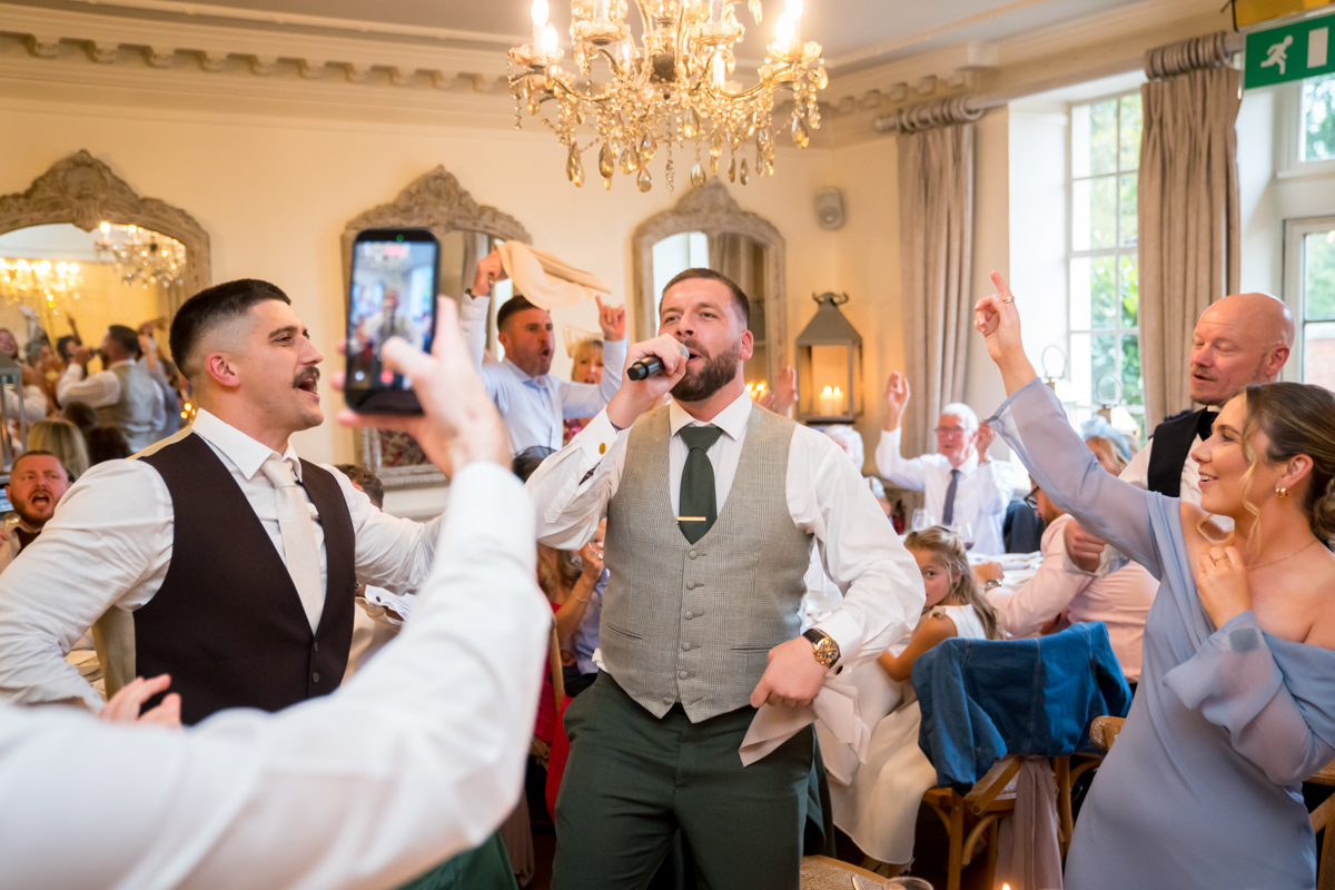 Wedding guests enjoying live singing performance.