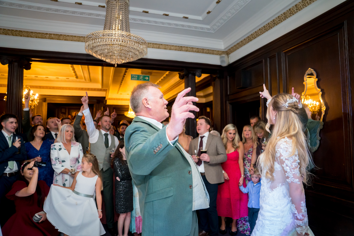Bride and guests enjoying wedding reception dance.