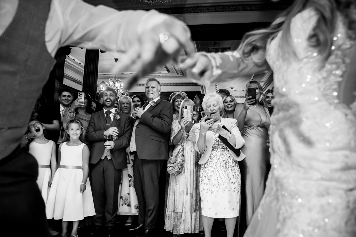 Wedding guests watching joyful dance performance.